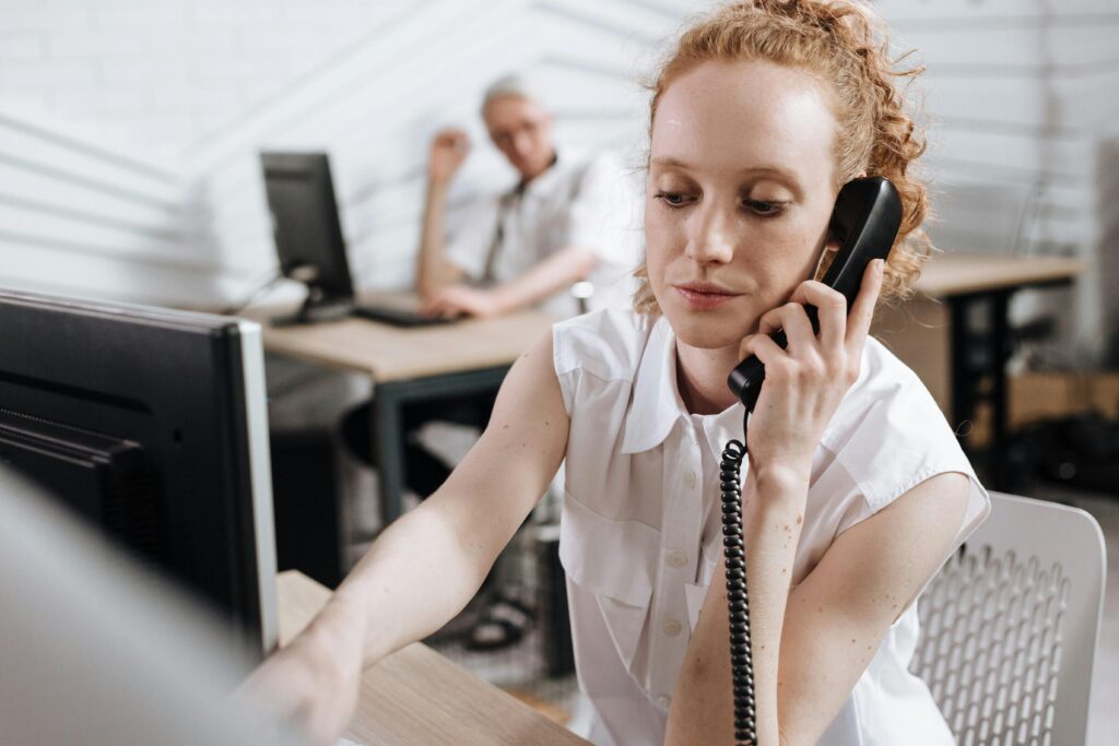 Focused businesswoman making phone call at her desk in a modern office.